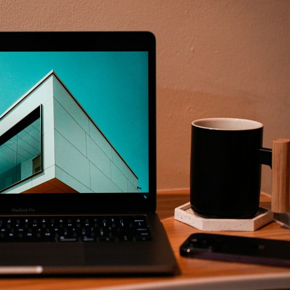 a laptop computer sitting on top of a wooden desk